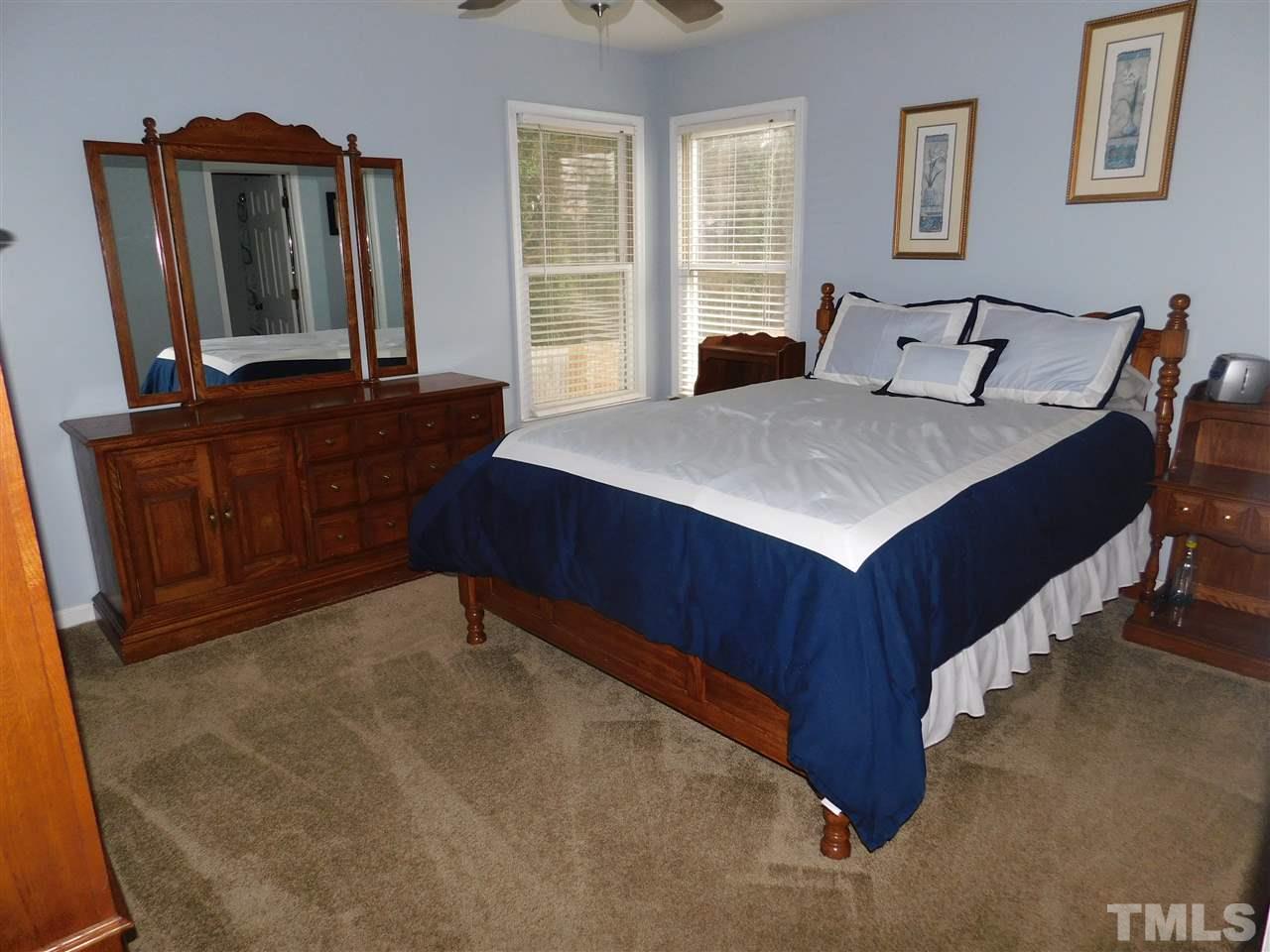 4428 Roller Court Raleigh, NC 27604 - Photo 8 of 10 a bedroom with a bed and a mirror on dresser