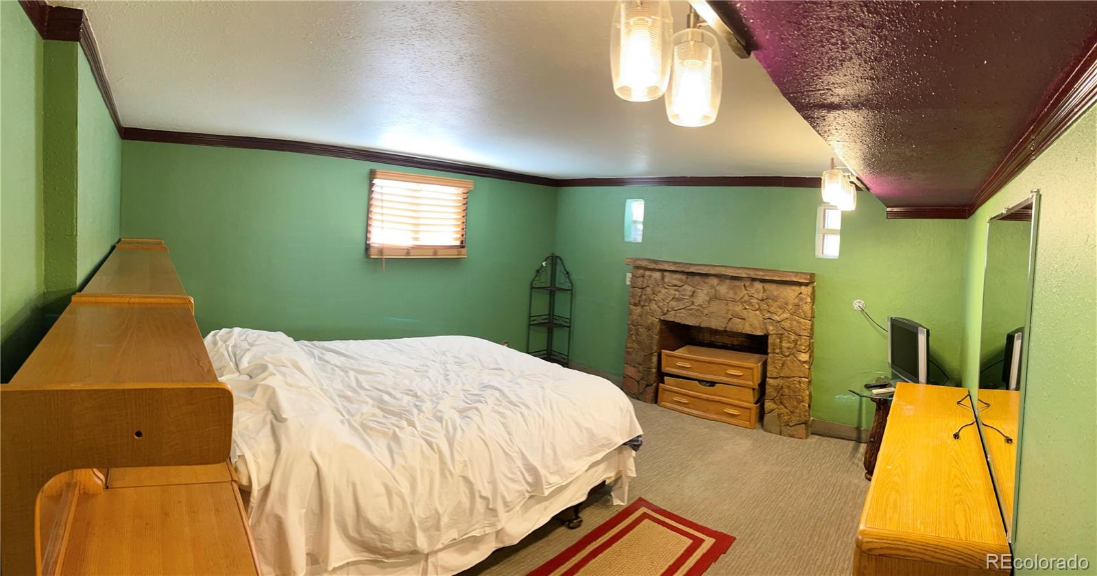 317 9th Street Gilcrest, CO 80623 - Photo 11 of 15 a bedroom with a bed and a fireplace