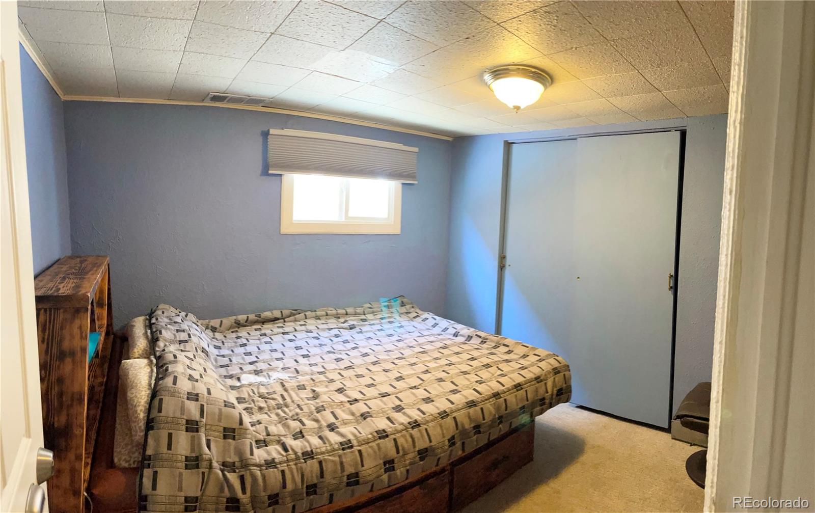 317 9th Street Gilcrest, CO 80623 - Photo 12 of 15 a bedroom with a bed and a window