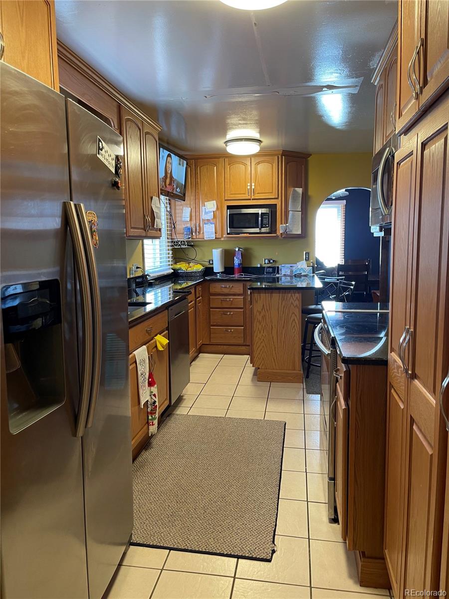 317 9th Street Gilcrest, CO 80623 - Photo 8 of 15 a kitchen with stainless steel appliances granite countertop a refrigerator a sink a stove and a refrigerator