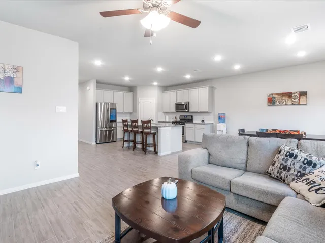 a living room with furniture kitchen and a table