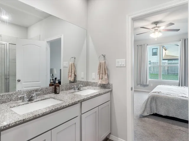 a en suite bathroom with a double vanity sink and a mirror