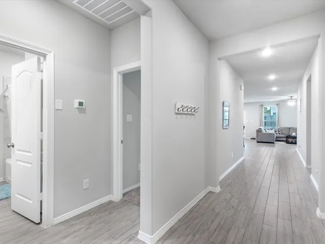 a view of a hallway with wooden floor windows and a livingroom