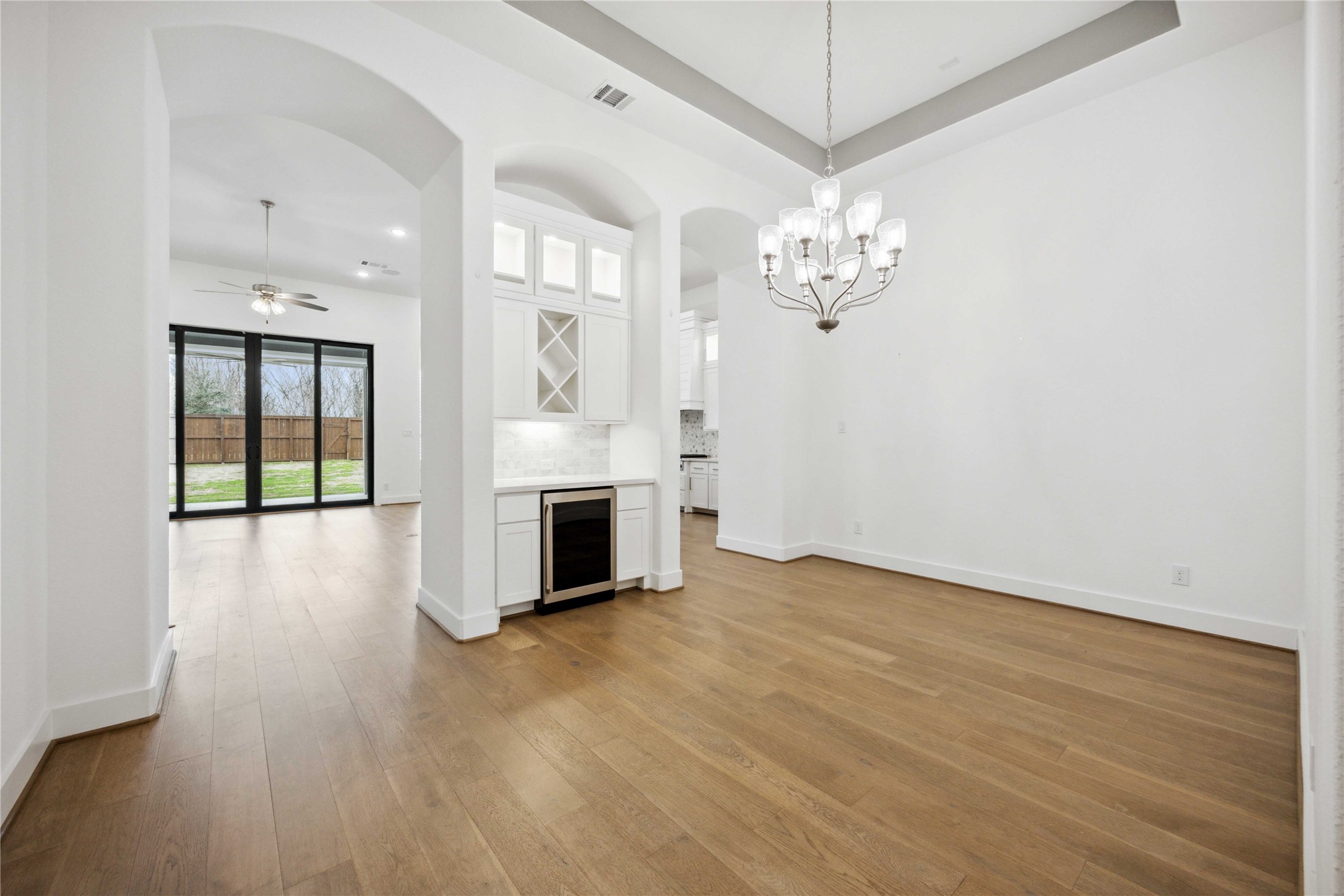 2711 Merlin Way Katy, TX 77493 - Photo 4 of 50 View of formal dining room with wine fridge and living room and kitchen in the background