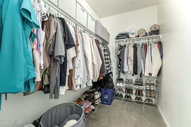 a view of walk in closet with clothes and shoes