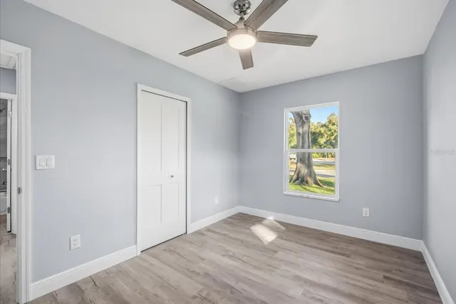 an empty room with window and wooden floor