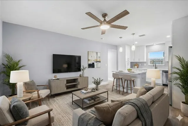 a living room with furniture kitchen view and a flat screen tv