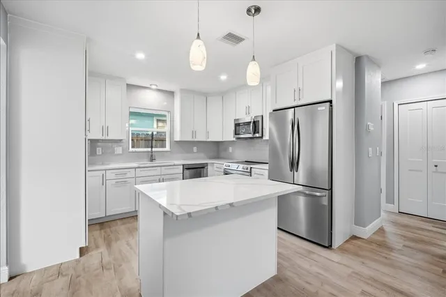 a kitchen with a refrigerator a sink and cabinets