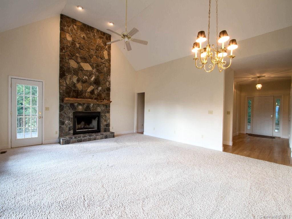 686 Fontana View Road, Unit 56 Bryson City, NC 28713 - Photo 4 of 24 a view of a livingroom with a fireplace a chandelier and windows