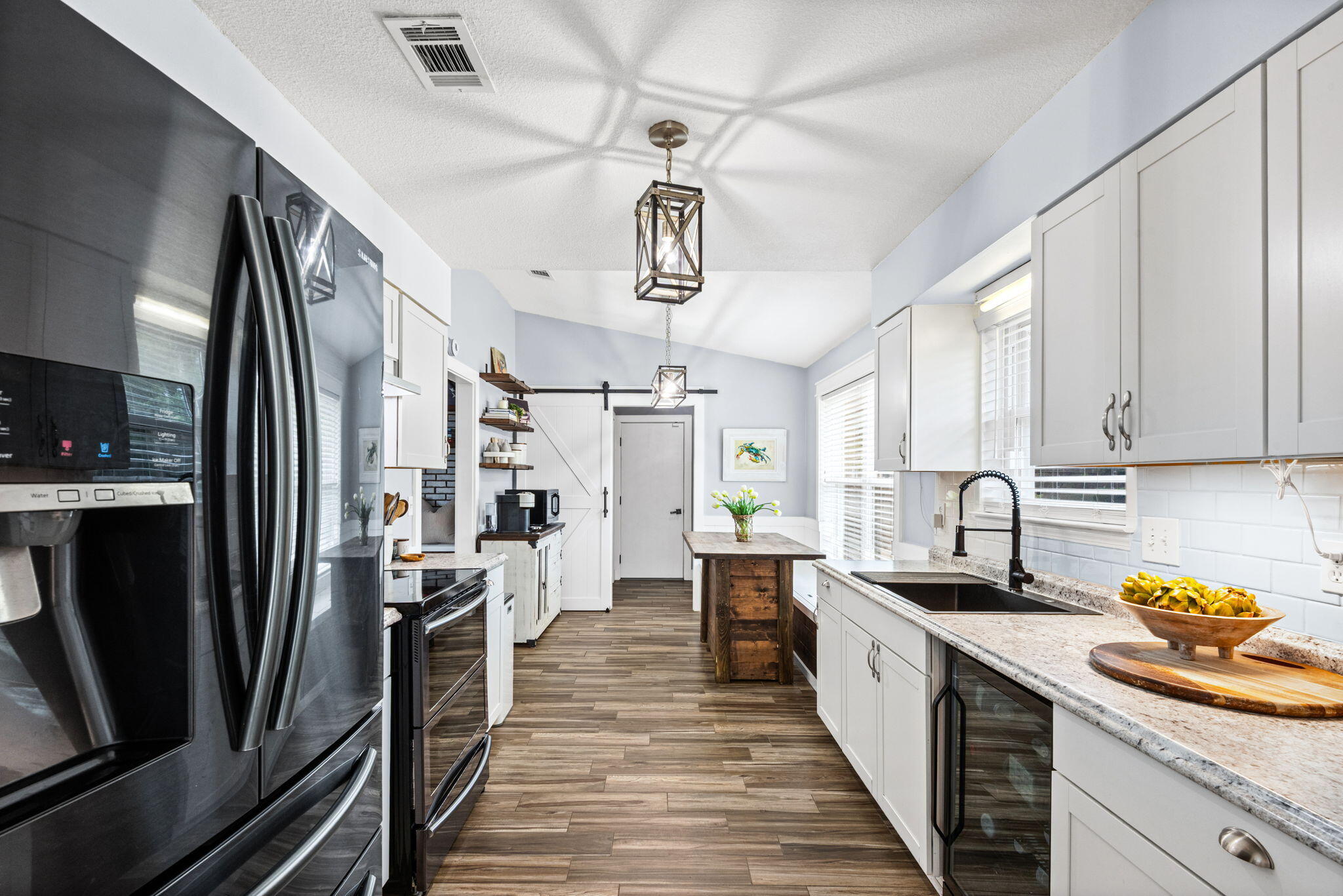 943 Ridgewood Way Niceville, FL 32578 - Photo 12 of 42 a kitchen with stainless steel appliances a refrigerator a sink a stove white cabinets and wooden floor