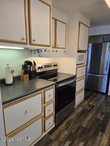 a kitchen with stainless steel appliances granite countertop a refrigerator and a stove