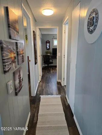 a view of a hallway with wooden floor and stairs