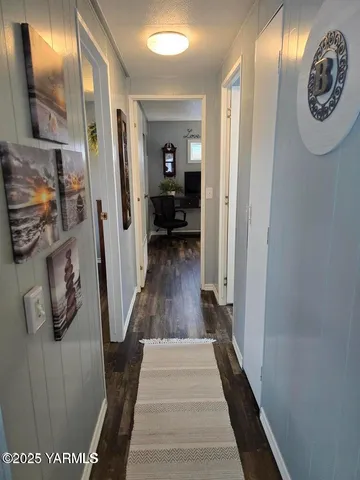 a view of a hallway with wooden floor and stairs