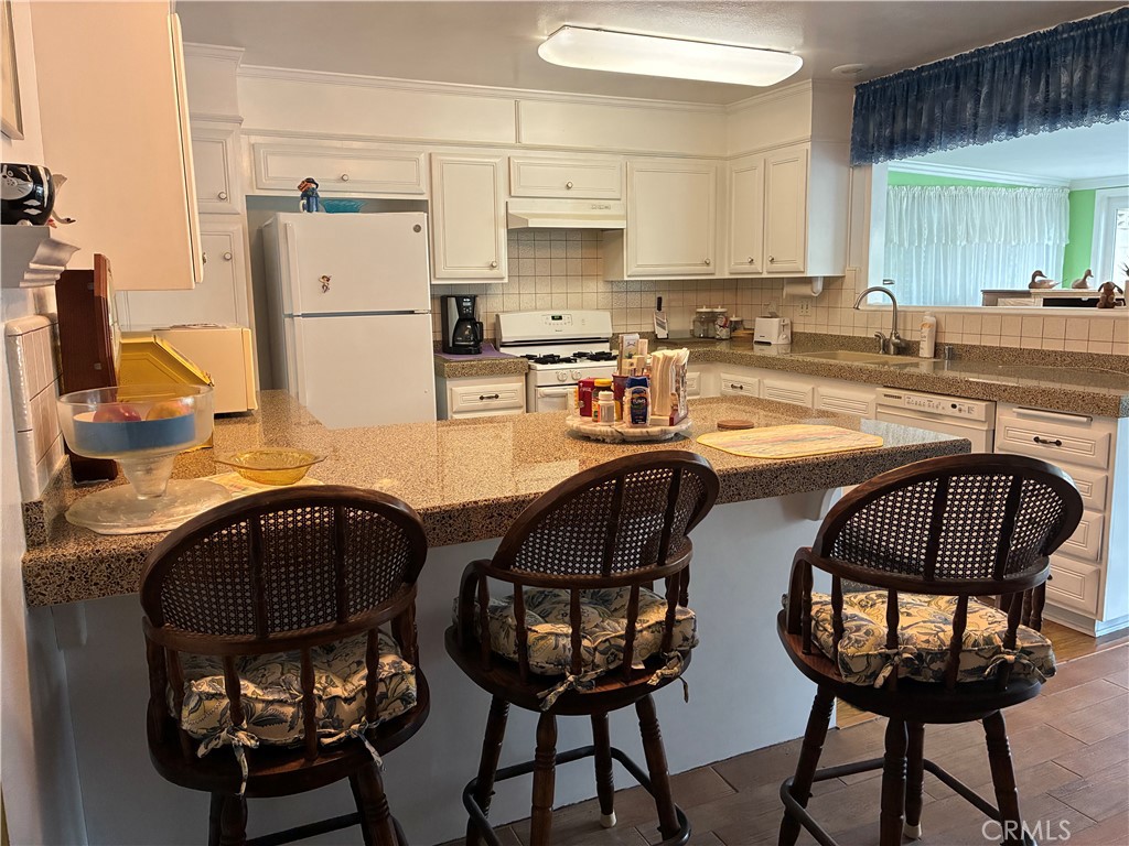 10456 Hamilton Street Rancho Cucamonga, CA 91701 - Photo 9 of 17 a kitchen with a dining table chairs and a refrigerator