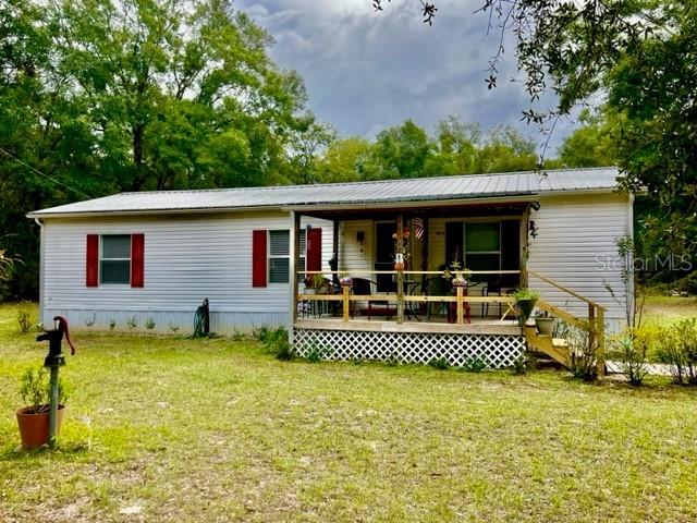 6669 Northwest 36th Lane Bell, FL 32619 - Photo 12 of 39 a front view of a house with a garden