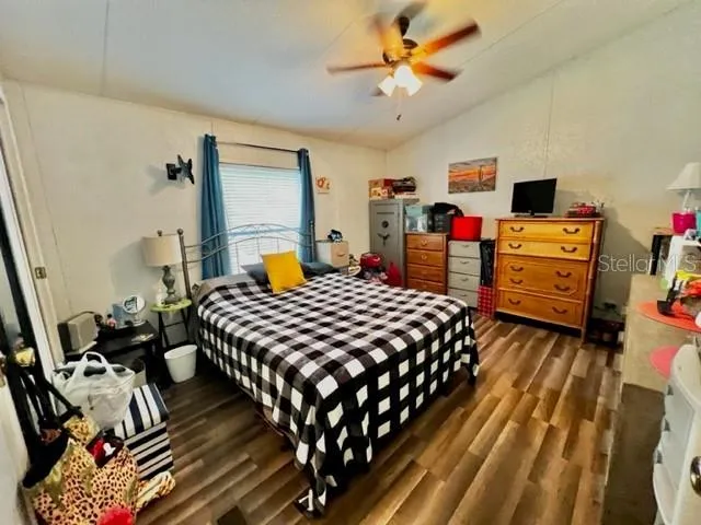 a bedroom with bed and wooden floor