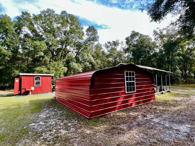 6669 Northwest 36th Lane Bell, FL 32619 - Photo 36 of 39 a backyard of a house with wooden fence and trees