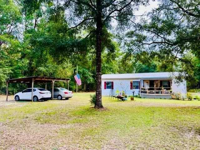 a view of swimming pool with outdoor seating and house in the background