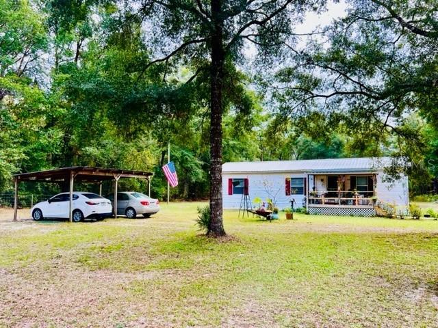 6669 Northwest 36th Lane Bell, FL 32619 - Photo 8 of 39 a view of swimming pool with outdoor seating and house in the background