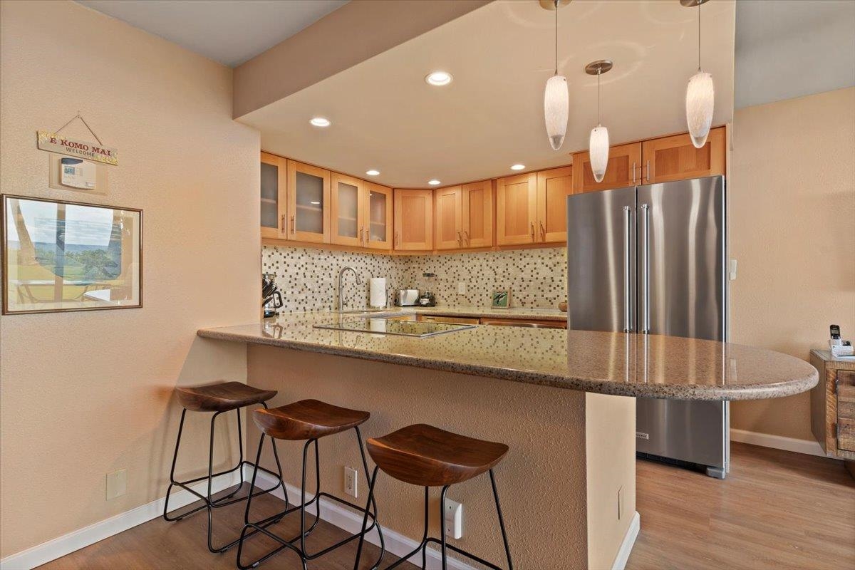 36 South Kihei Road, Unit 103 Kihei, HI 96753 - Photo 12 of 37 a kitchen with stainless steel appliances granite countertop a sink a stove a refrigerator and island with wooden floor