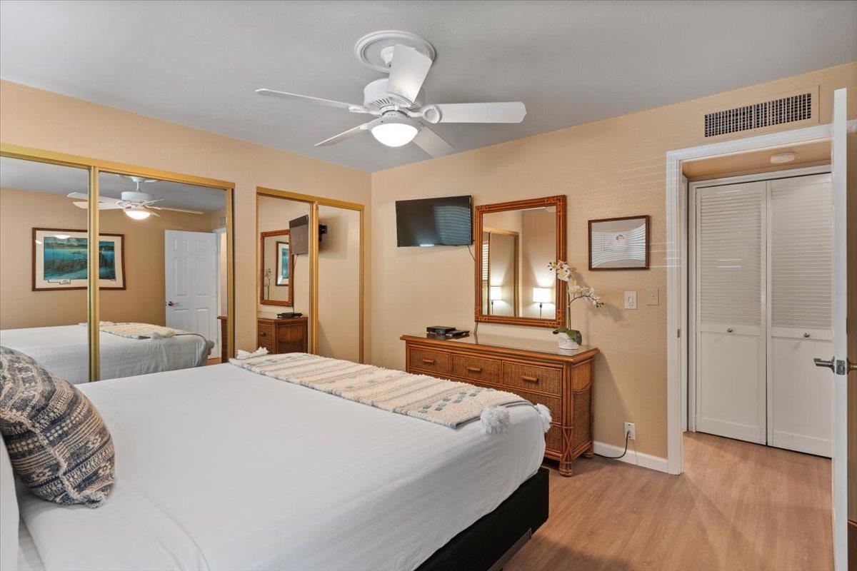 36 South Kihei Road, Unit 103 Kihei, HI 96753 - Photo 27 of 37 a bedroom with a large bed and a chandelier