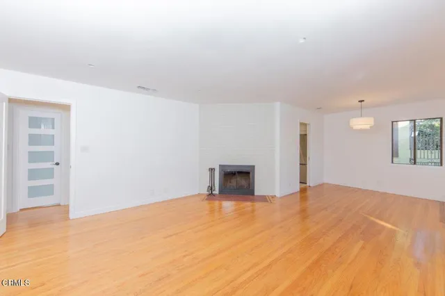 a view of empty room with wooden floor