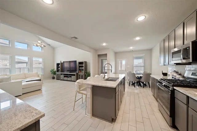 a living room with stainless steel appliances granite countertop lots of counter top space and furniture