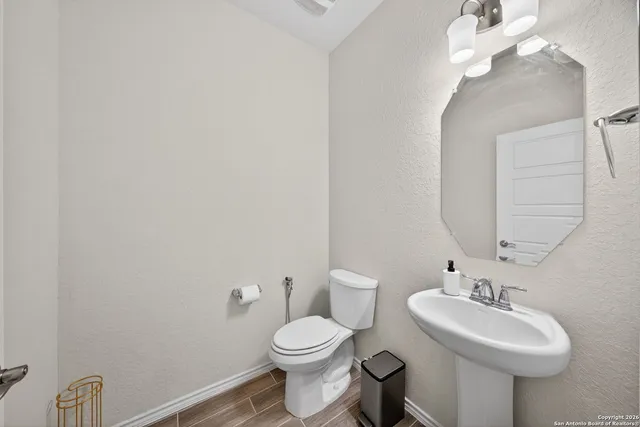 a bathroom with a toilet sink and mirror