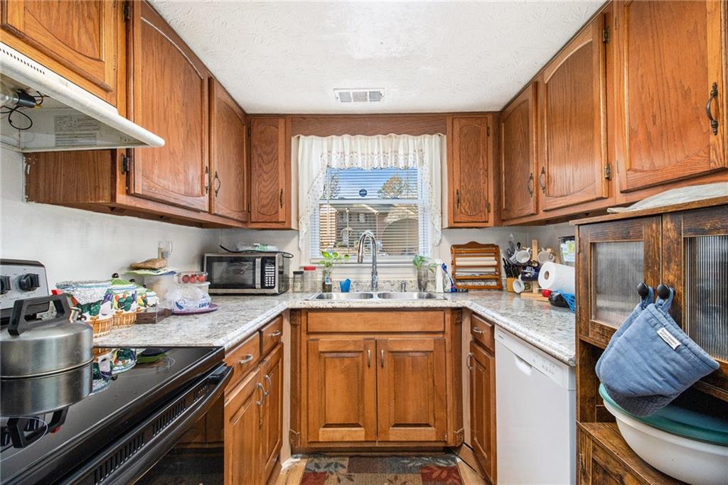 4526 Golf Vista Circle Decatur, GA 30035 - Photo 12 of 31 a kitchen with stainless steel appliances granite countertop a sink stove and cabinets