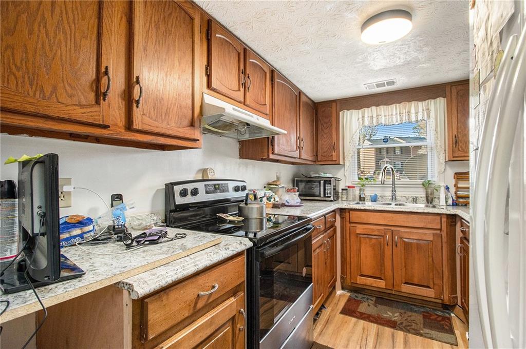 4526 Golf Vista Circle Decatur, GA 30035 - Photo 13 of 31 a kitchen with stainless steel appliances granite countertop a stove and a sink