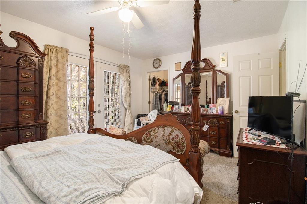 4526 Golf Vista Circle Decatur, GA 30035 - Photo 18 of 31 a bedroom with a bed a television and dresser with wooden floor