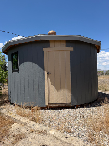255 E Centre Spring City, UT 84662 - Photo 32 of 34 Octagonal outbuilding with dark gray siding and beige trim, featuring a single window and a solid door