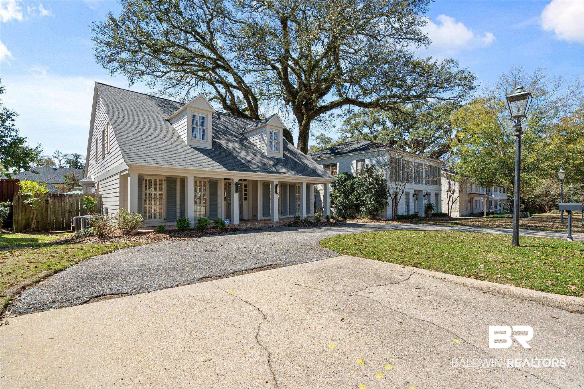 3921 McGregor Court Mobile, AL 36608 - Photo 40 of 41 View of front of home with driveway, a porch, fence, roof with shingles, and central AC unit