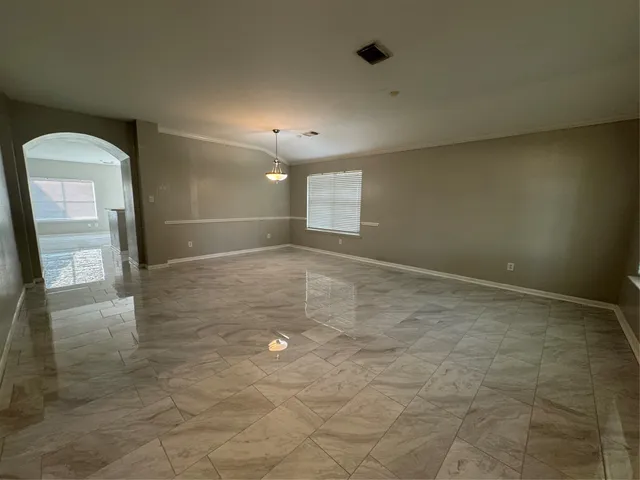a view of an empty room with a fireplace and a window