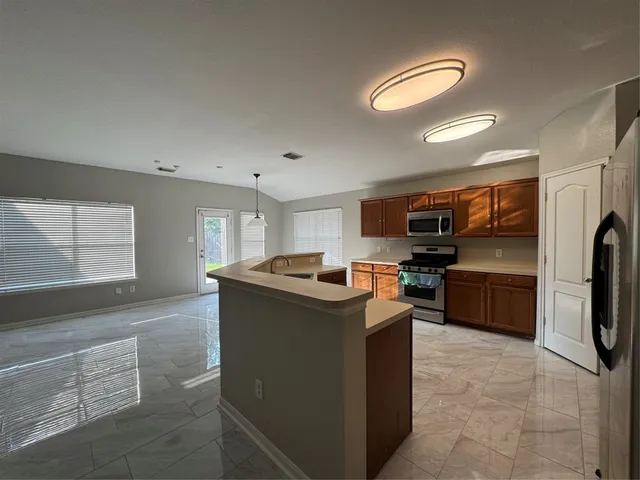 a kitchen with stainless steel appliances granite countertop a stove a microwave and a refrigerator