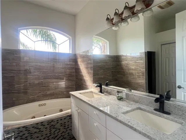 a bathroom with a tub sink and mirror