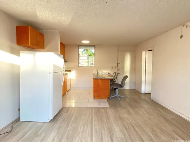 a kitchen with stainless steel appliances a refrigerator and wooden floor