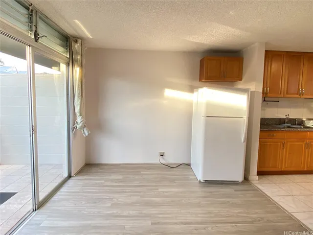 a view of a refrigerator in kitchen and wooden floor