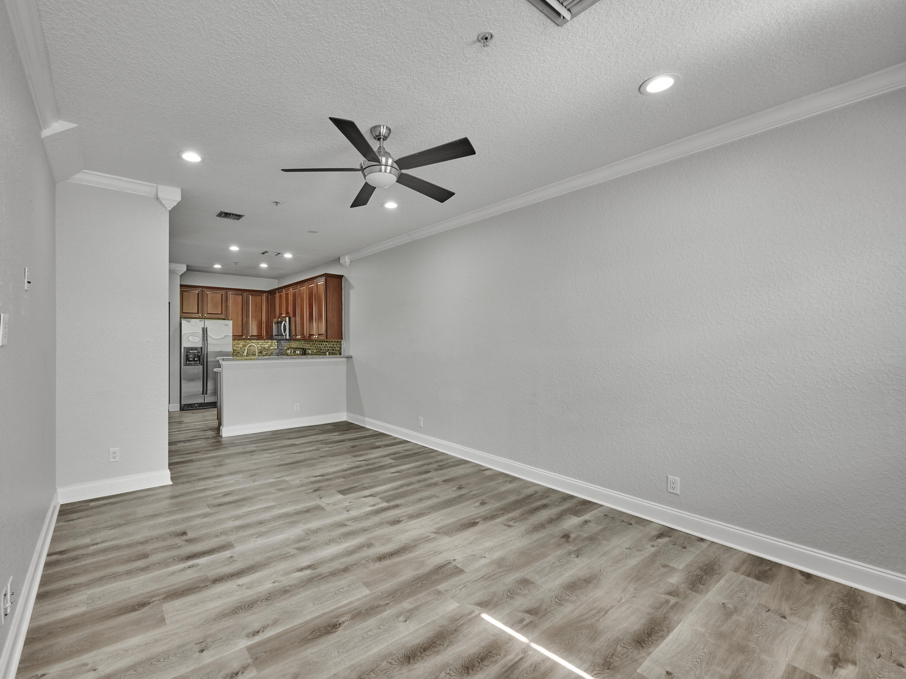 105 East Pigeon Plum Drive, Unit 103 Jupiter, FL 33458 - Photo 9 of 38 a view of a livingroom with wooden floor and a ceiling fan