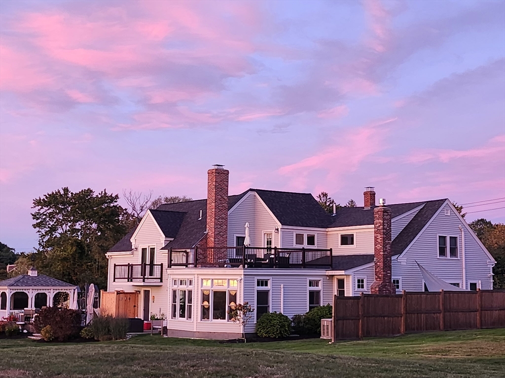 a view of a big house with a big yard and large trees