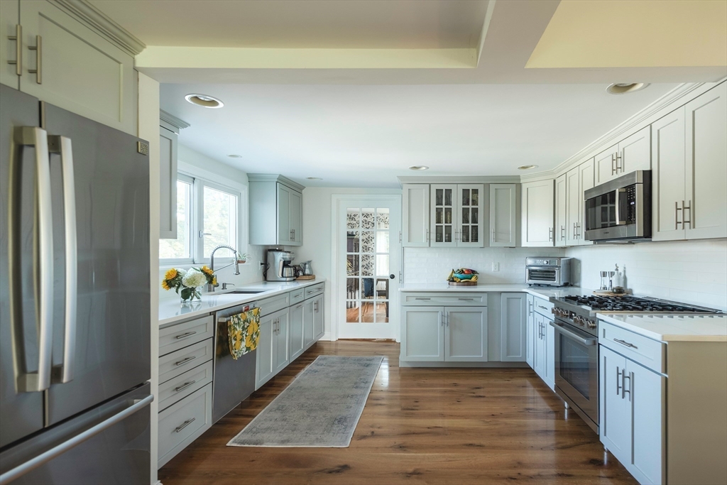 50 Jeffrey's Neck Road Ipswich, MA 01938 - Photo 16 of 41 a large kitchen with a stove top oven a sink dishwasher and a refrigerator with wooden floor