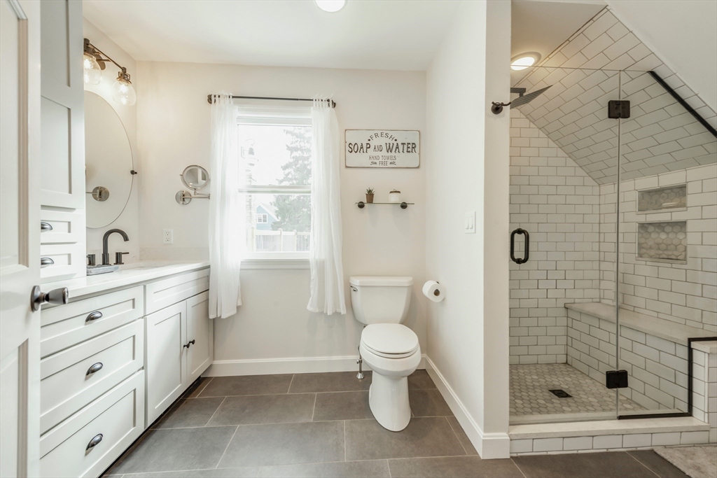 50 Jeffrey's Neck Road Ipswich, MA 01938 - Photo 33 of 41 a bathroom with a granite countertop sink toilet a shower and a mirror