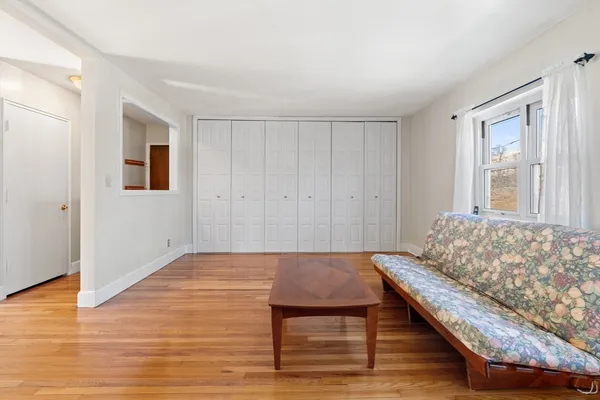 a bedroom with wooden floor and windows