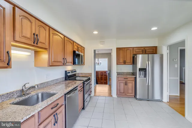 a kitchen with stainless steel appliances granite countertop a refrigerator and a sink