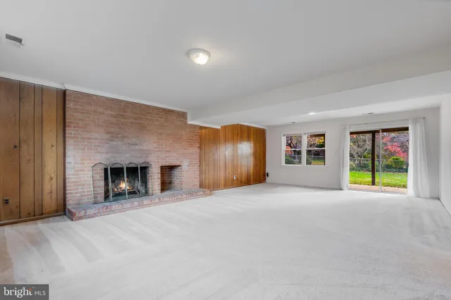 a view of an empty room with a fireplace and a window