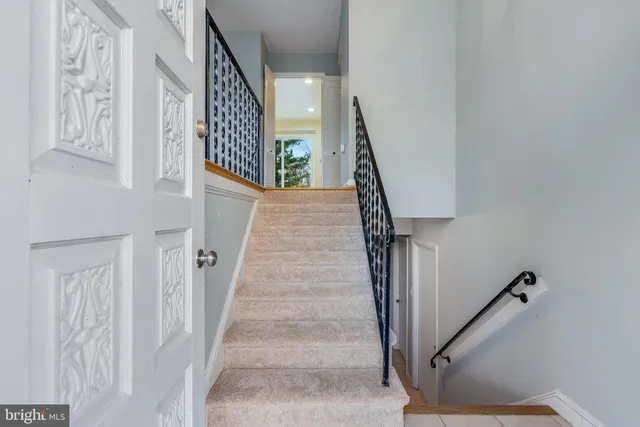 a view of staircase with lots of frames on wall and paintings on the wall