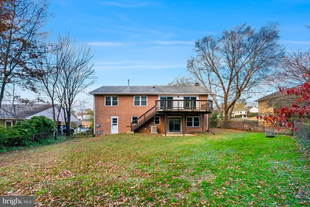 a view of a house with a big yard and large tree