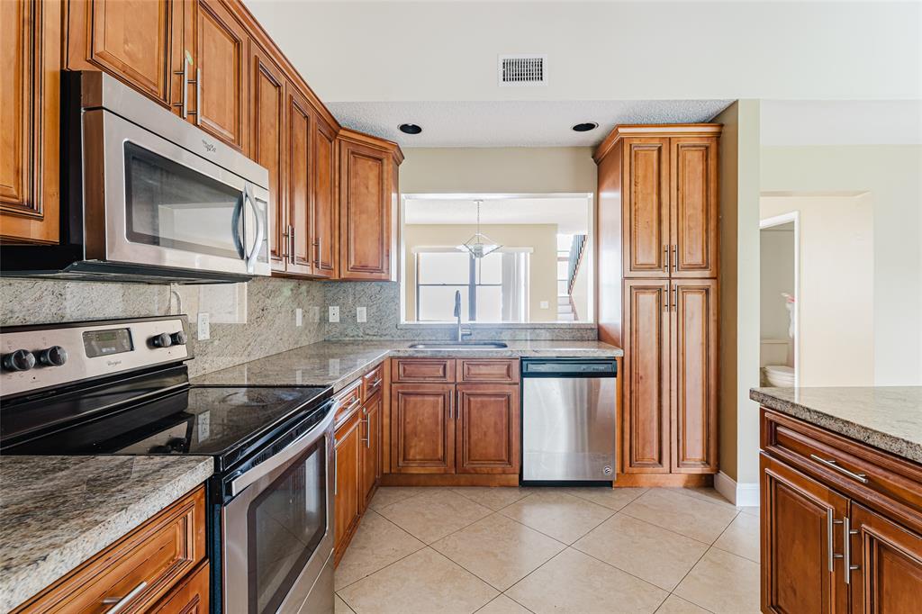 Undisclosed Address Boca Raton, FL 33428 - Photo 16 of 36 a kitchen with stainless steel appliances granite countertop a refrigerator a stove a sink and dishwasher