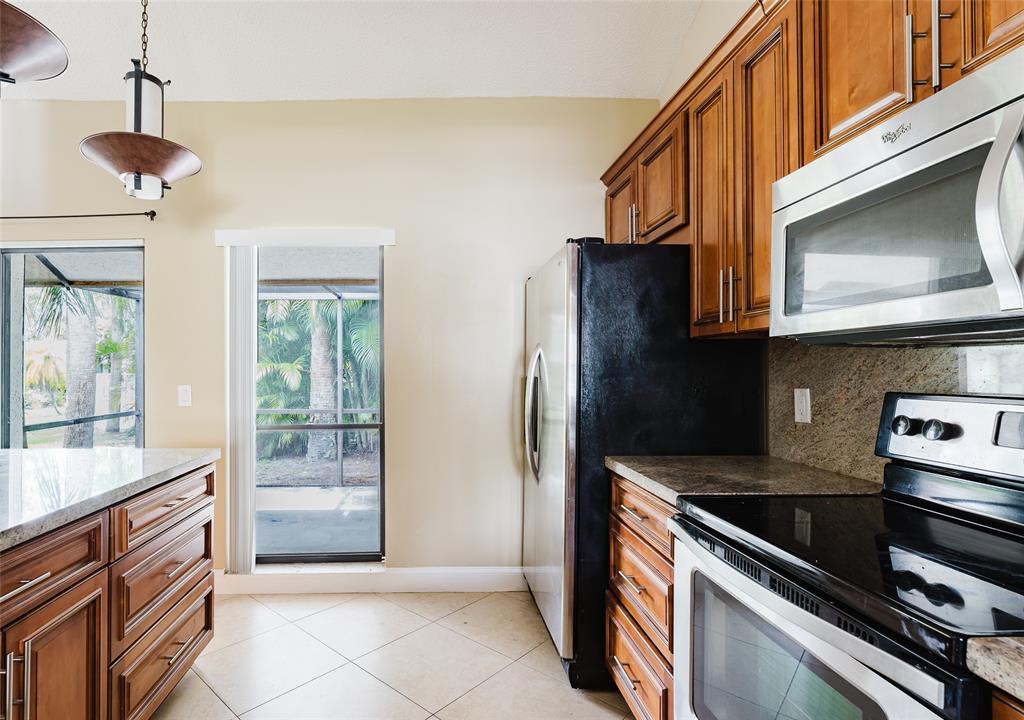 Undisclosed Address Boca Raton, FL 33428 - Photo 17 of 36 a kitchen with stainless steel appliances granite countertop a stove and a microwave
