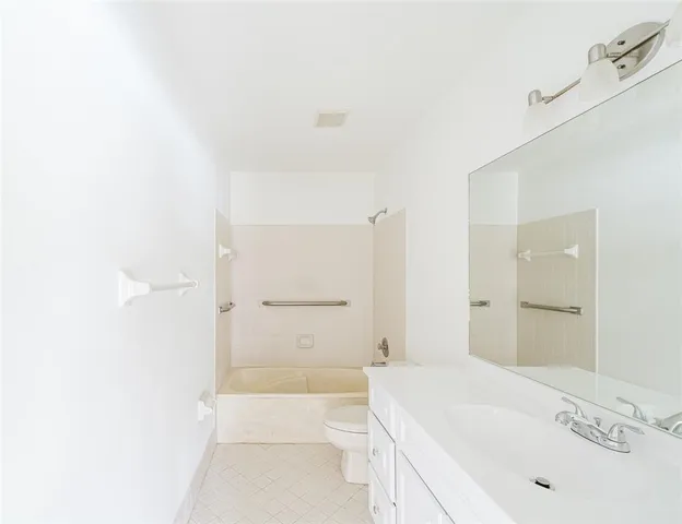 a bathroom with a granite countertop sink a toilet and shower